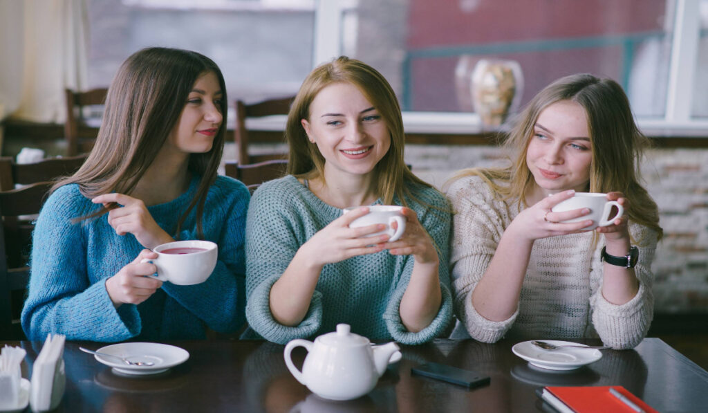 A group of women laughing and talking over coffee women's health