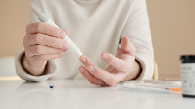 A close-up of a doctor’s hand holding a clipboard or performing a blood pressure check health care