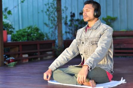 A person meditating in a peaceful outdoor setting or practicing deep breathing exercises heart health