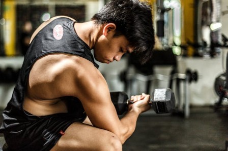 A close-up of someone doing bicep curls with dumbbells gym workout