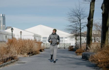 A dynamic shot of a runner mid-stride on a park path workouts outside