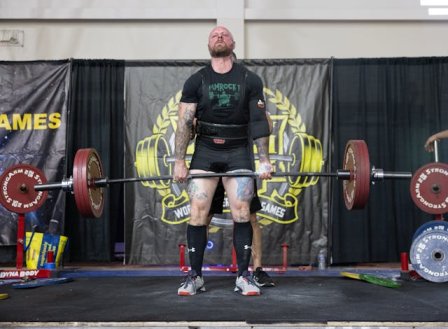  A muscular athlete performing squats with a barbell gym workout