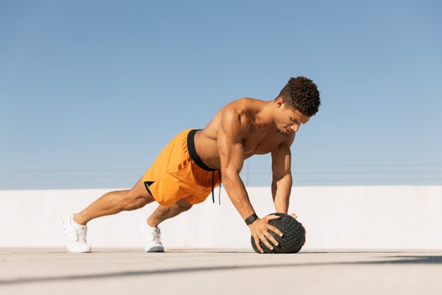 A Man is Building Muscle with Men’s Health Magazines